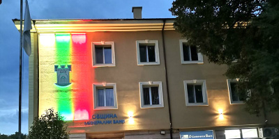 Фасадата на община Минерални бани свети в бяло, зелено, червено